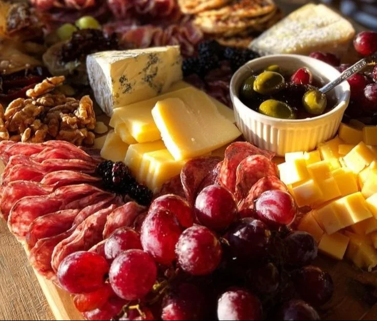 Beautiful Christmas charcuterie board filled with festive cheeses, meats, and garnishes.