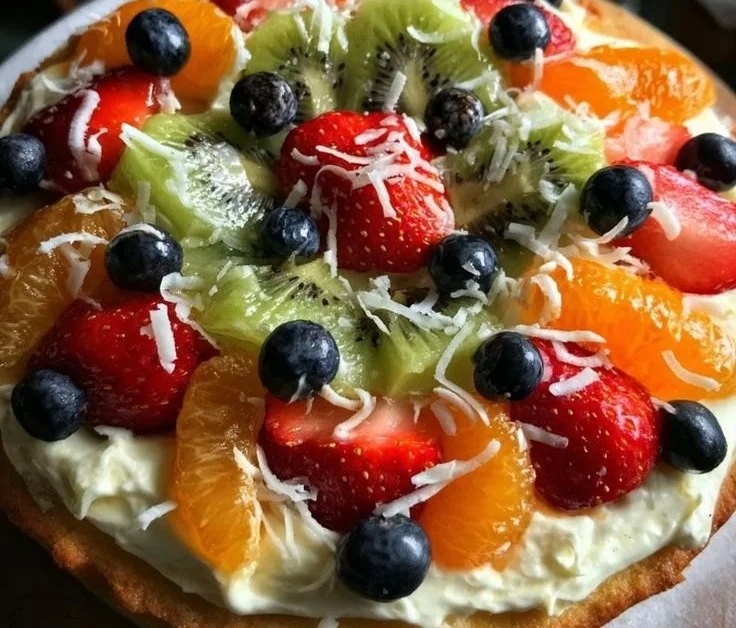 Festive Christmas fruit pizza topped with colorful fresh fruits and cream