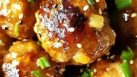 Savory pineapple teriyaki meatballs served on a plate with garnish